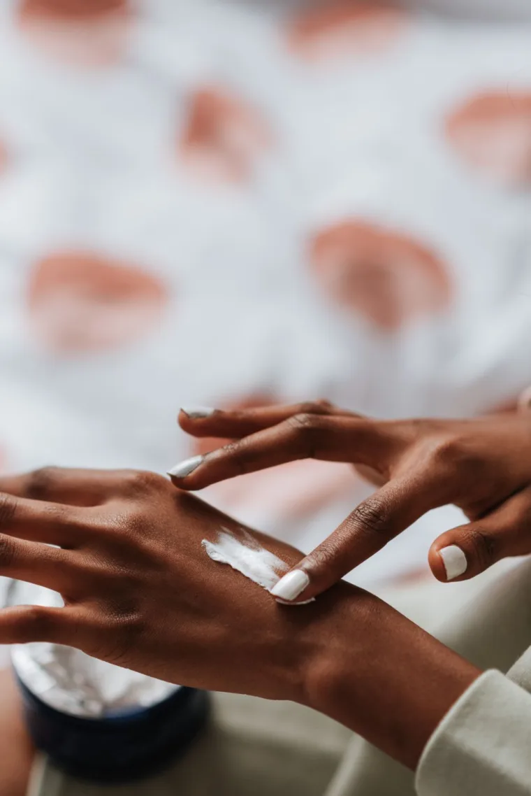 Hands applying body butter